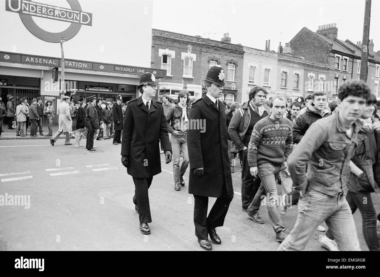 La polizia a mantenere un occhio su Leeds United sostenitori all'Arsenal Football Ground come tifosi arrivano alla stazione Arsenale in anticipo del match. Il 29 gennaio 1983. Foto Stock