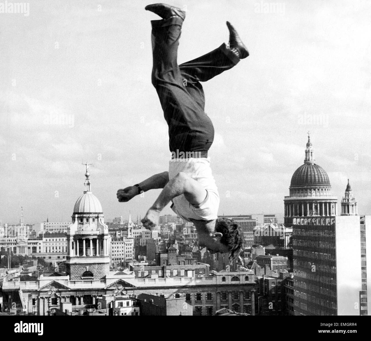 Acrobat Frank Paulo salta capovolto su un trampolino sul tetto dell'edificio GPO a Londra come egli ripete per l annuale varietà Club Show di beneficenza a Billy Smart il Circus in Shephered's Bush. Sullo sfondo sono la centrale di Corte penale (l'Old Bailey) e alla Cattedrale di St Paul. Il 15 ottobre 1961. Foto Stock
