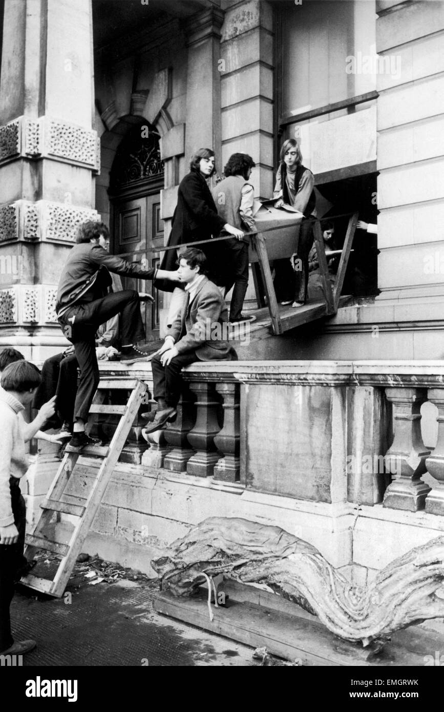 Numero 144 Piccadilly, una elegante sala 100 mansion nel West End di Londra è stata occupata dai stile self London Street comune che affermano di agire per le famiglie senzatetto. Nella foto sono alcuni degli hippies in movimento in una scatola di oggetti personali sui loro improvvisato ponte levatoio. Xvii Settembre 1969. Foto Stock