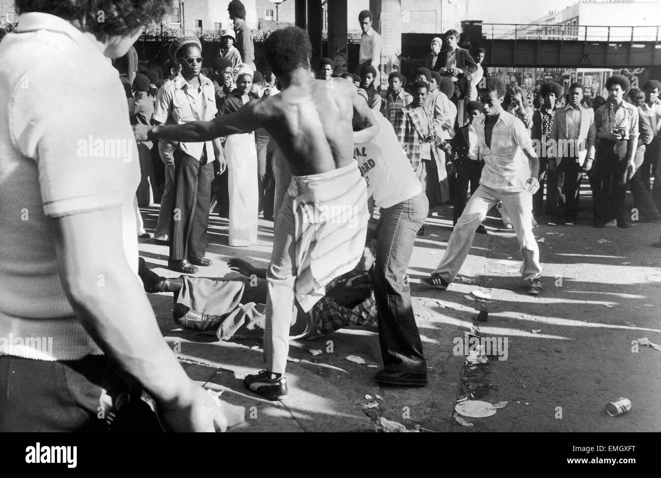 Un carnevale steward si sposta nel rompere una lotta a due fra i giovani al carnevale di Notting Hill. Il 30 agosto 1977. Foto Stock