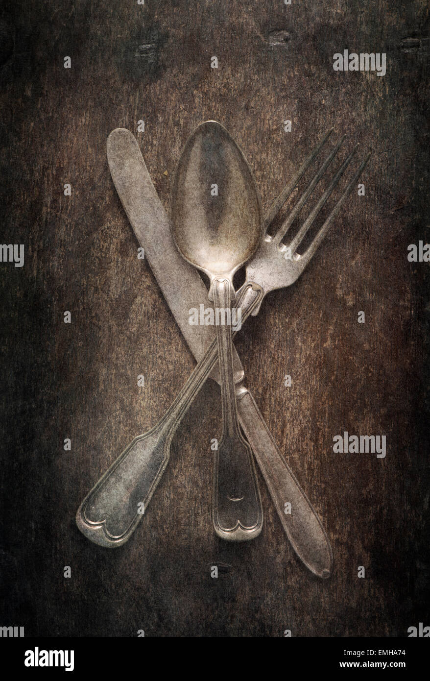 Ancora in vita con posate sul tavolo. Coltello, forchetta e cucchiaio su di un tavolo di legno. Foto Stock