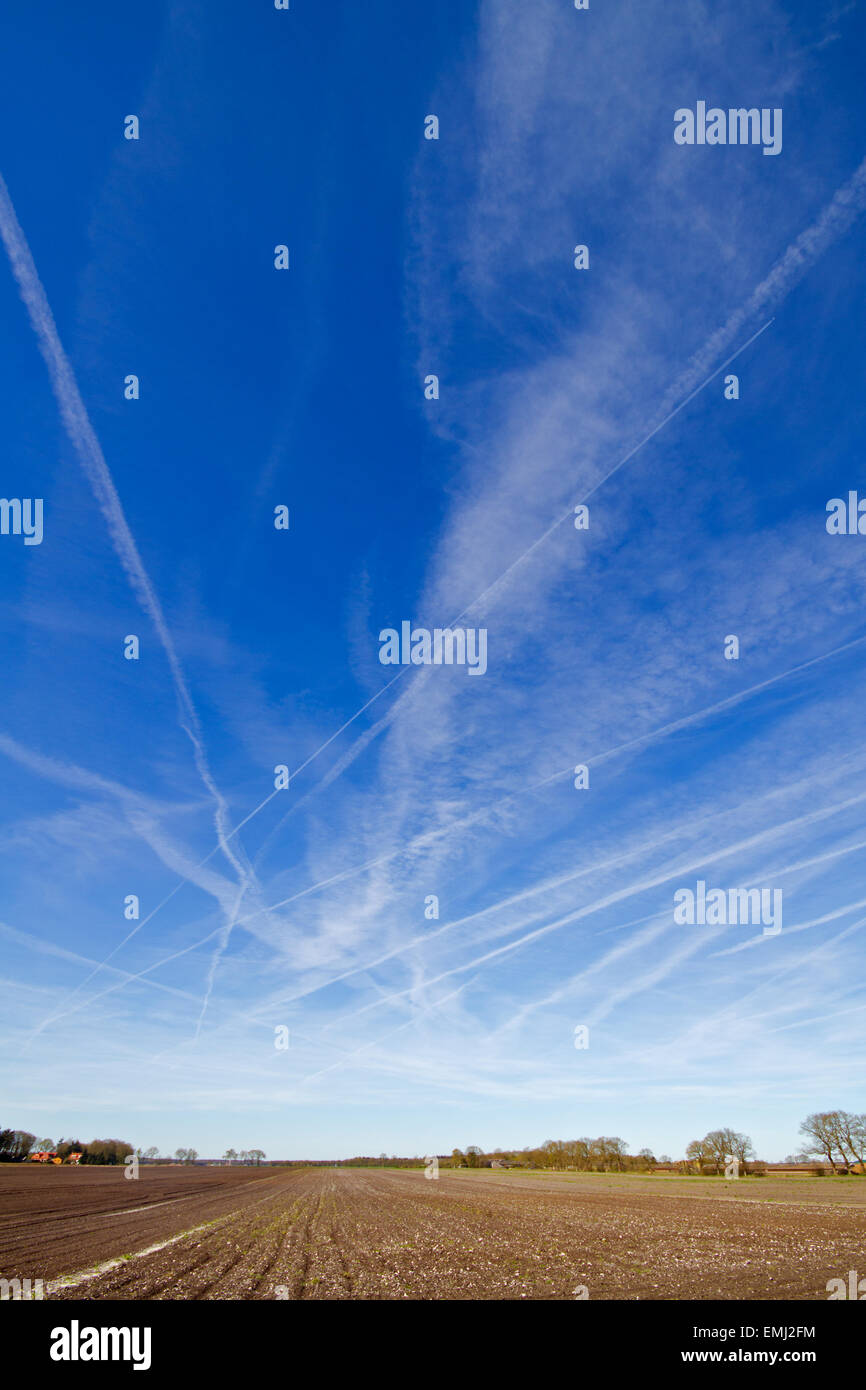 Un sacco di scie di condensazione, contrails o percorsi di vapore in un cielo blu Foto Stock