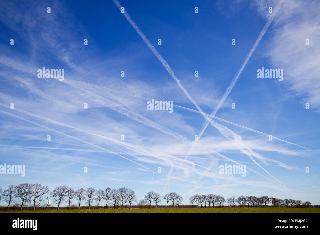 Un sacco di scie di condensazione, contrails o percorsi di vapore in un cielo blu Foto Stock