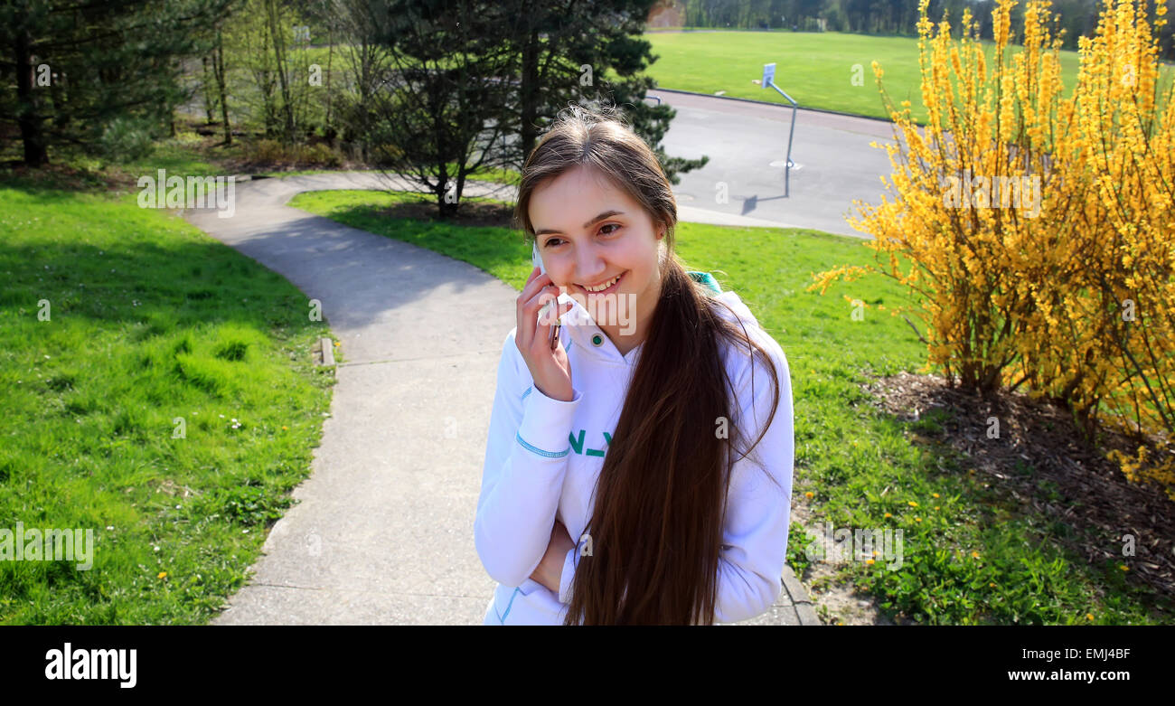 Bella giovane donna parlando al cellulare nel parco. Foto Stock