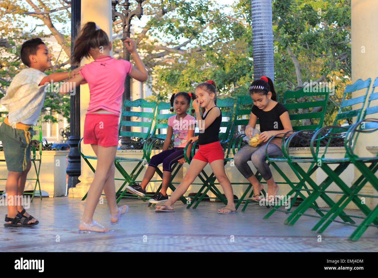 Giovani bambini cubani i ragazzi e le ragazze a giocare sulla fascia stand in Jose Marti Park Cienfuegos Cuba Foto Stock