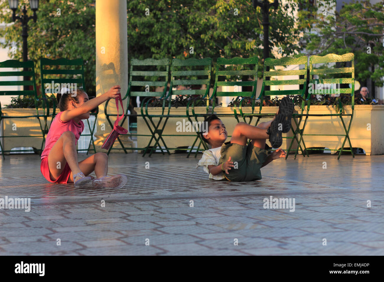 Giovani bambini cubani i ragazzi e le ragazze a giocare sulla fascia stand in Jose Marti Park Cienfuegos Cuba Foto Stock