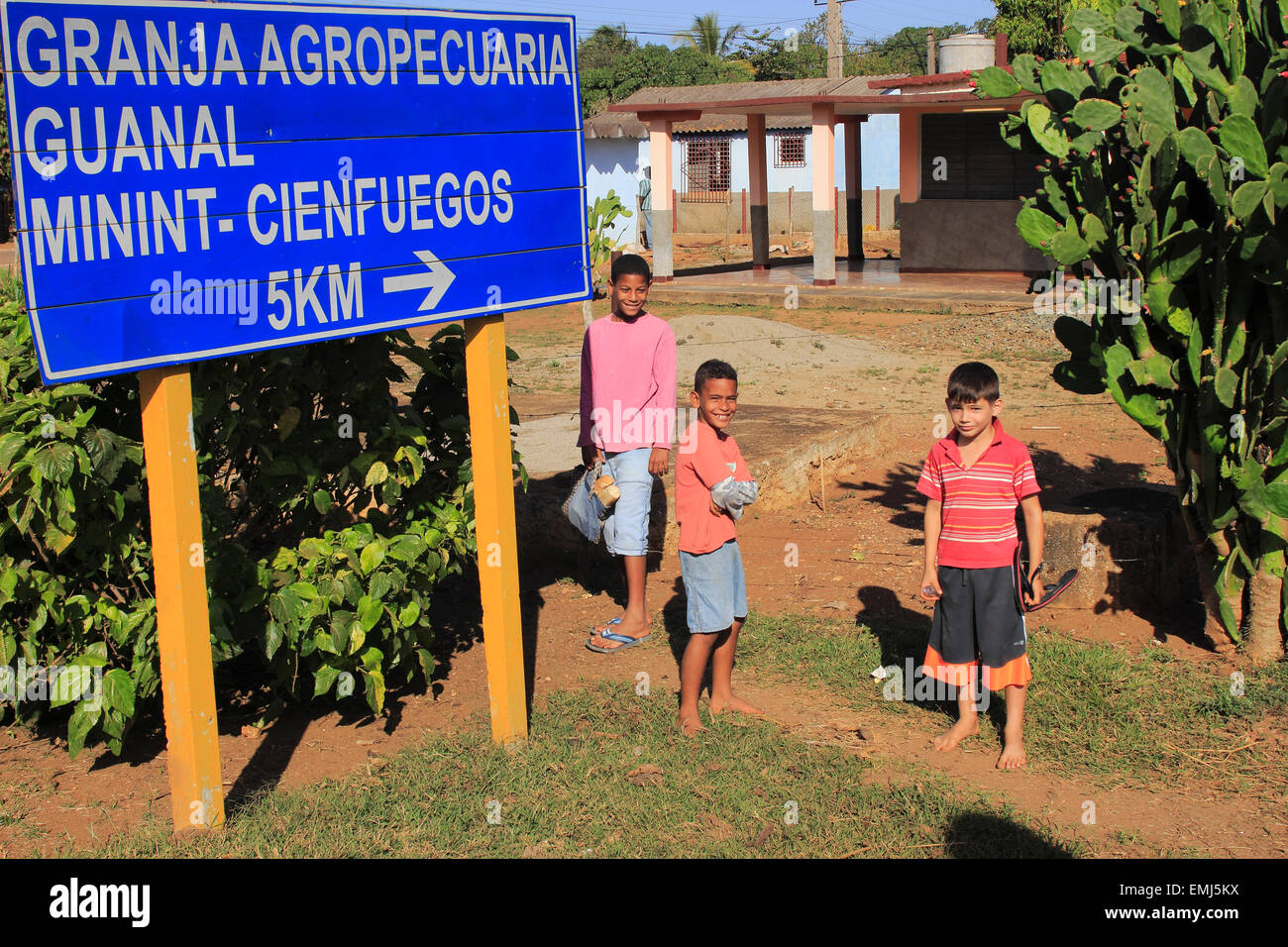 I bambini cubani ragazzi da una direzione strada segno in Playa Giron Cuba Foto Stock