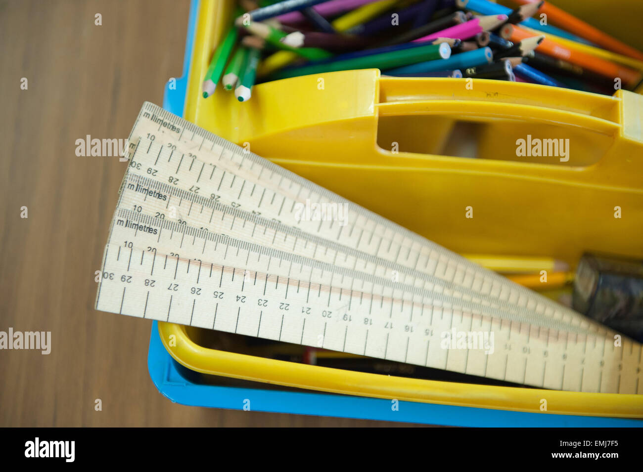 Una scatola di righelli e matite colorate in un aula DEL REGNO UNITO Foto Stock