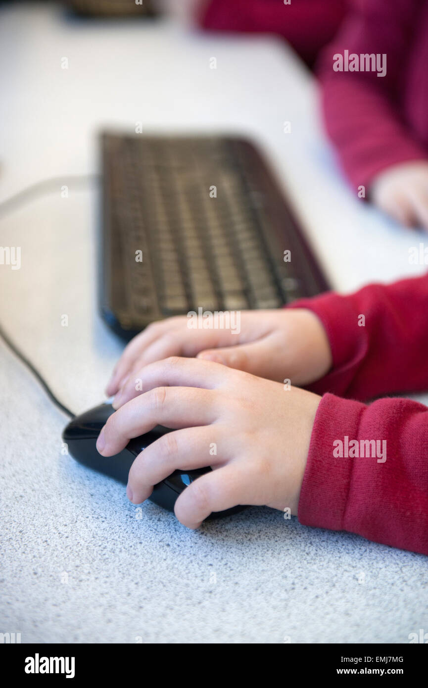 Regno Unito schoolboy usando un mouse e una tastiera in una lezione di TIC a scuola Foto Stock
