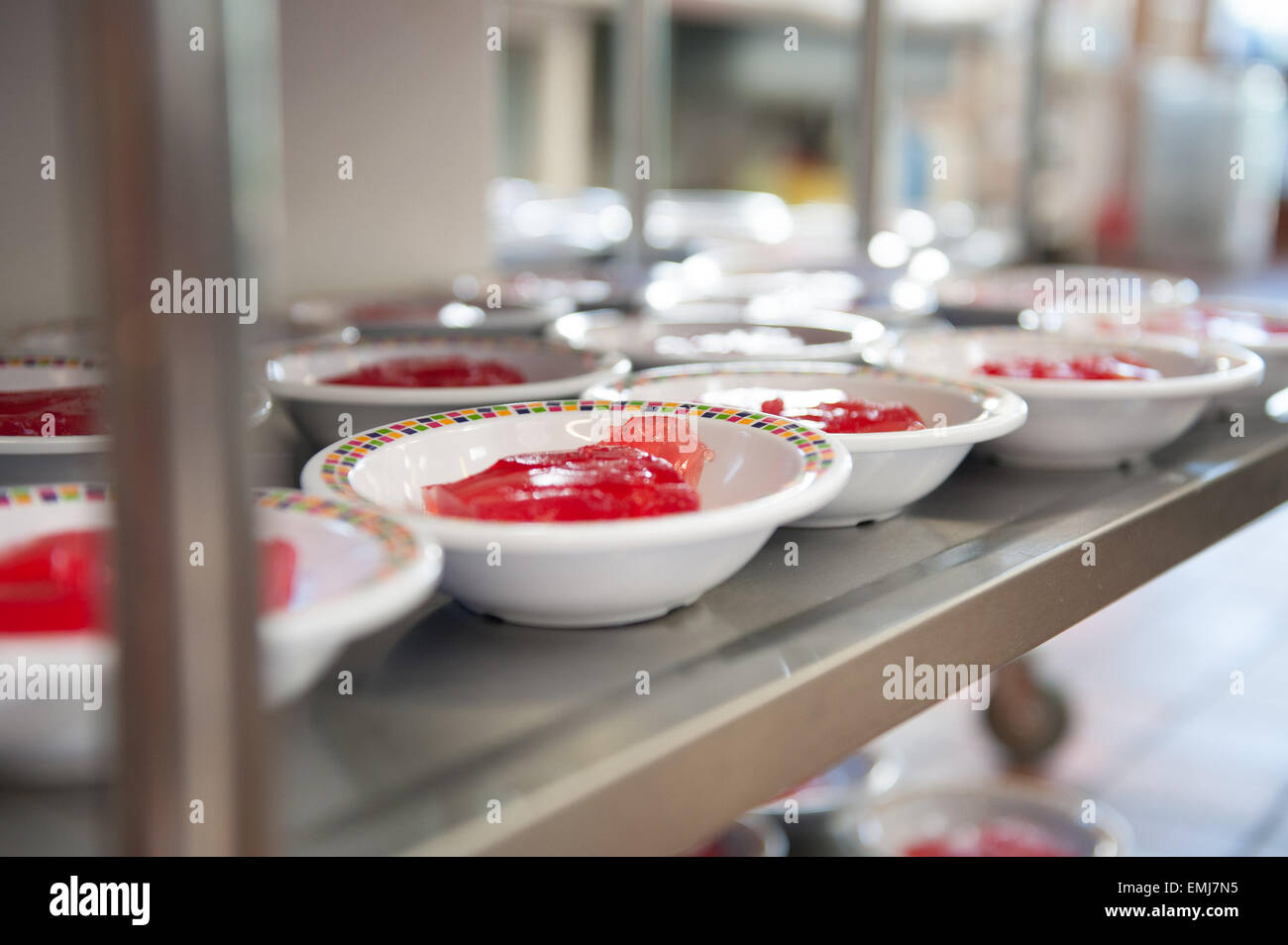 Bocce di marmellata di fragole su un carrello in una mensa scolastica Foto Stock