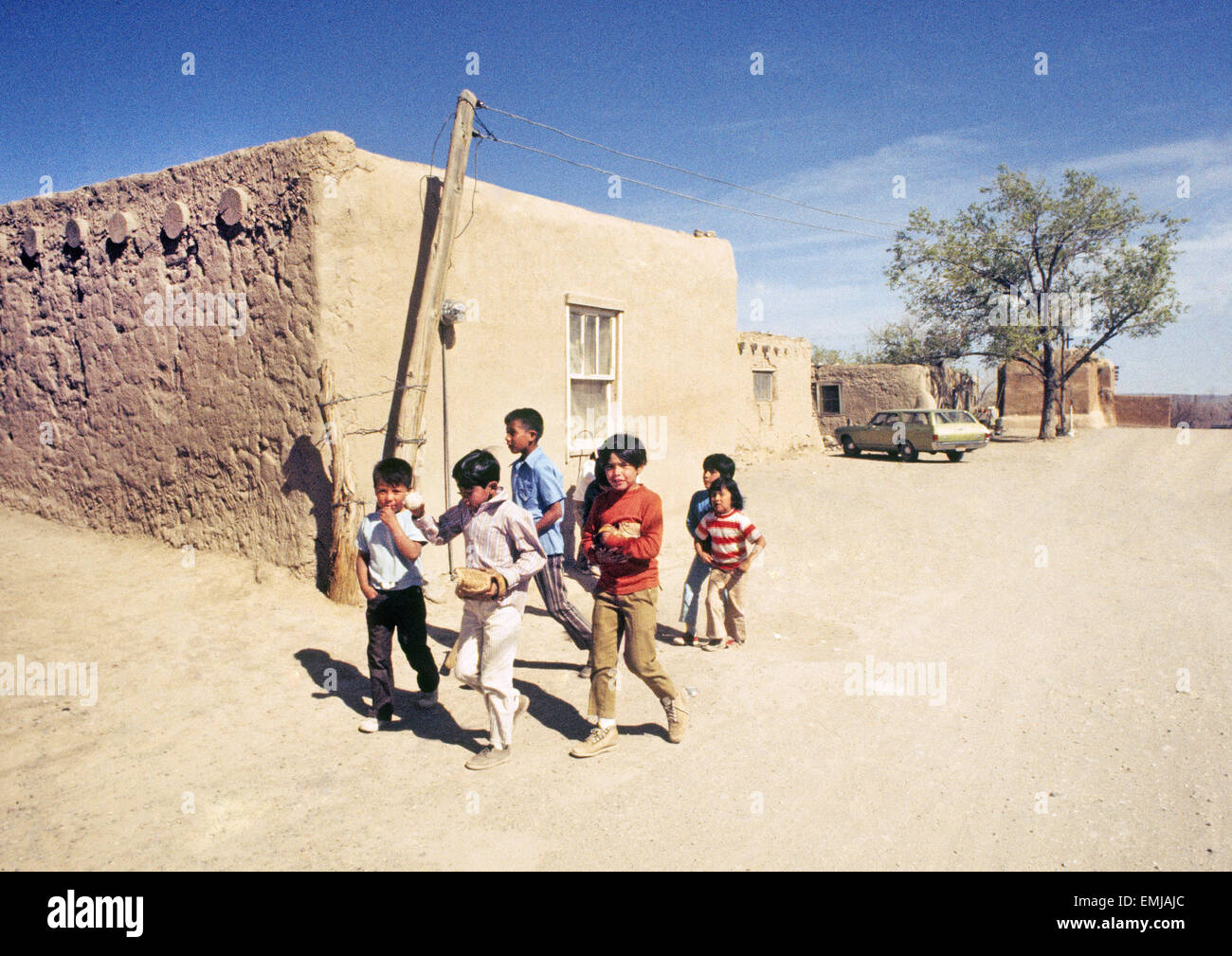 Un gruppo di giovani indiani bambini girovagare giù per una strada in Cochiti Indian Pueblo in un caldo pomeriggio d'estate. Foto Stock