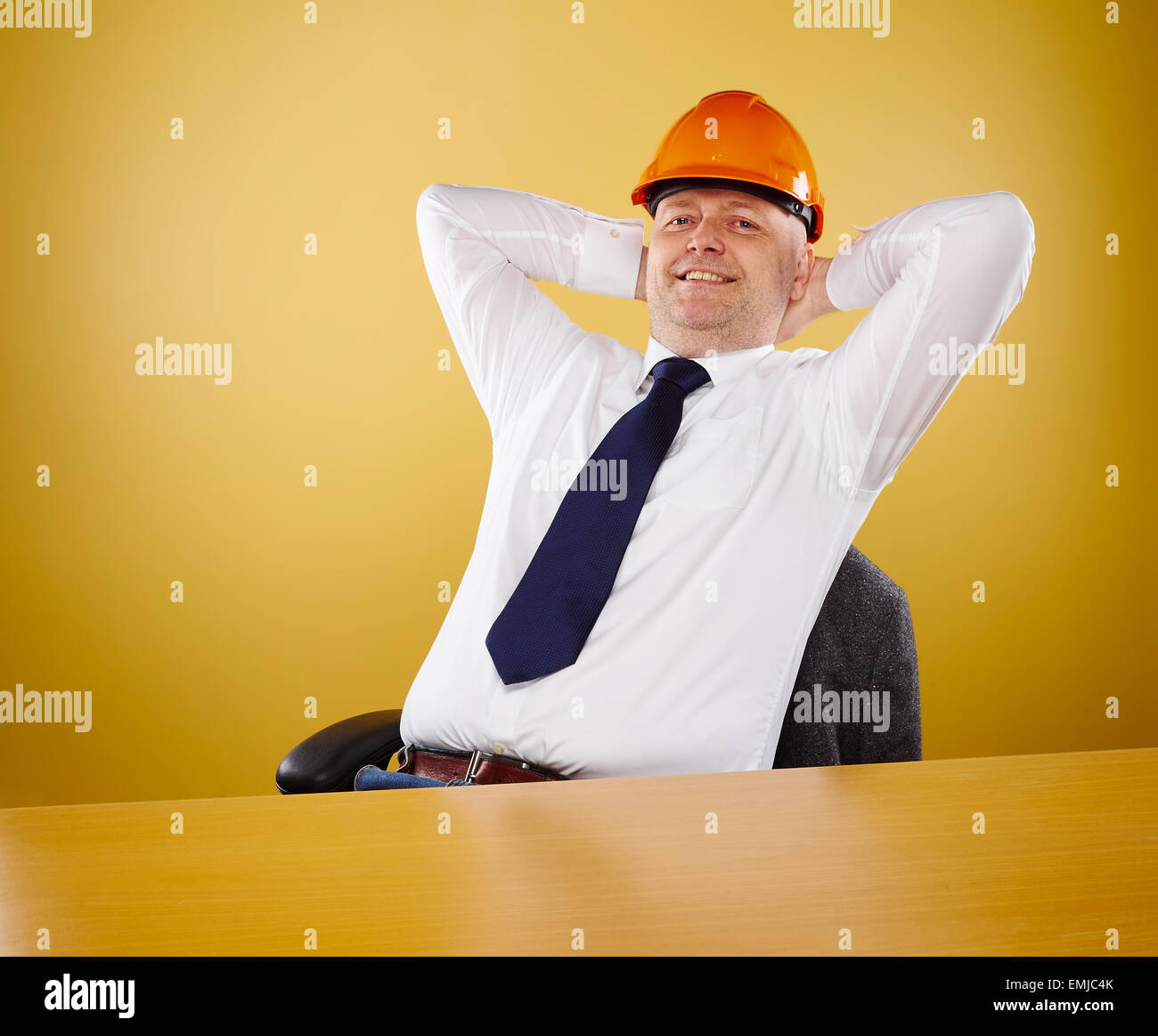 Ingegnere maschio in ufficio egli indossa una camicia bianca e cravatta, capo egli indossa una veste arancione elmetto Foto Stock