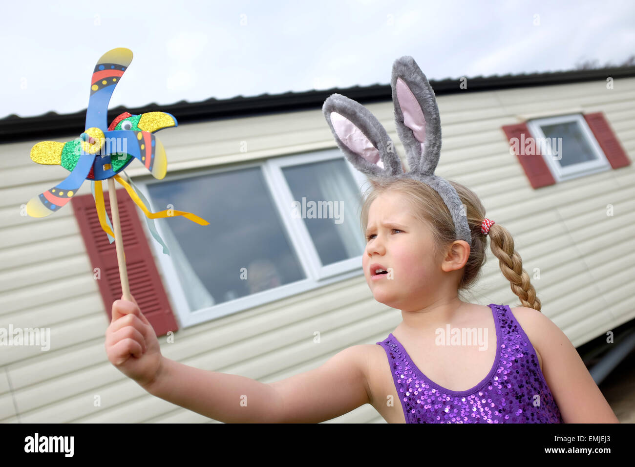 Una giovane ragazza che indossa coniglietto di pasqua le orecchie in vacanza in un caravan park per le vacanze di Pasqua Foto Stock