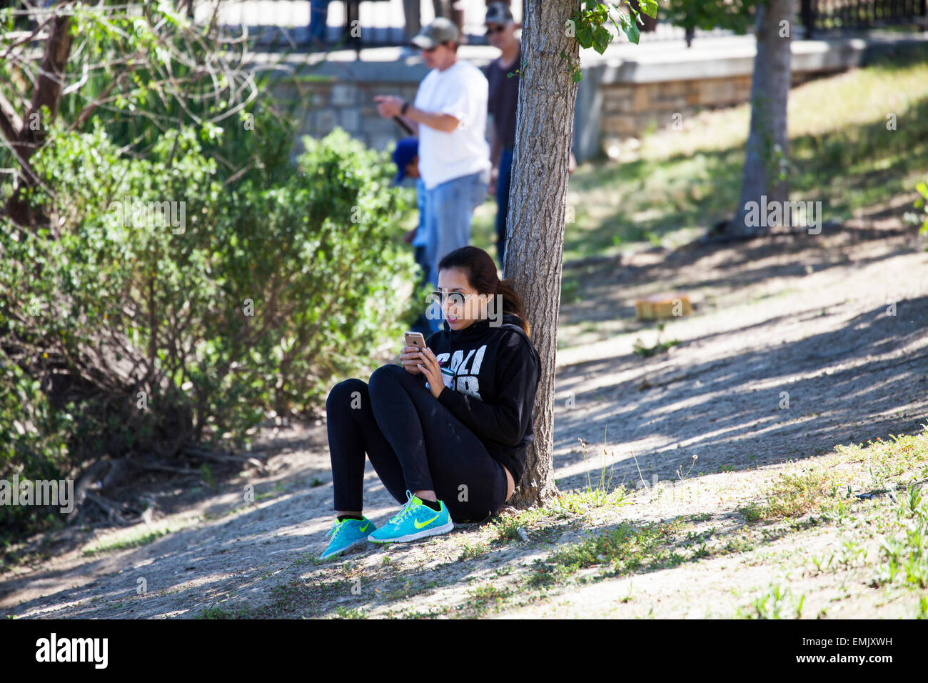 La donna gli sms in un parco, Novato, Marin County, California, Stati Uniti d'America Foto Stock