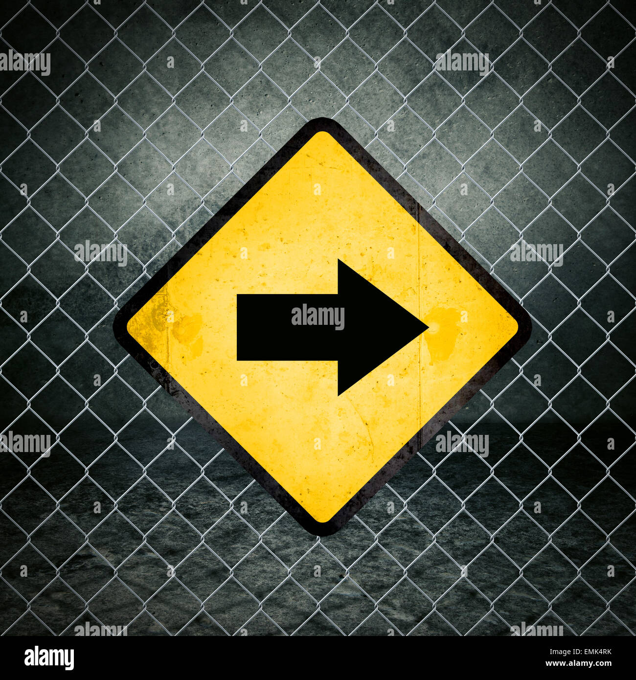 Giusta direzione Grunge simbolo giallo di avvertimento sulla recinzione ad anelli di magazzini industriali Foto Stock