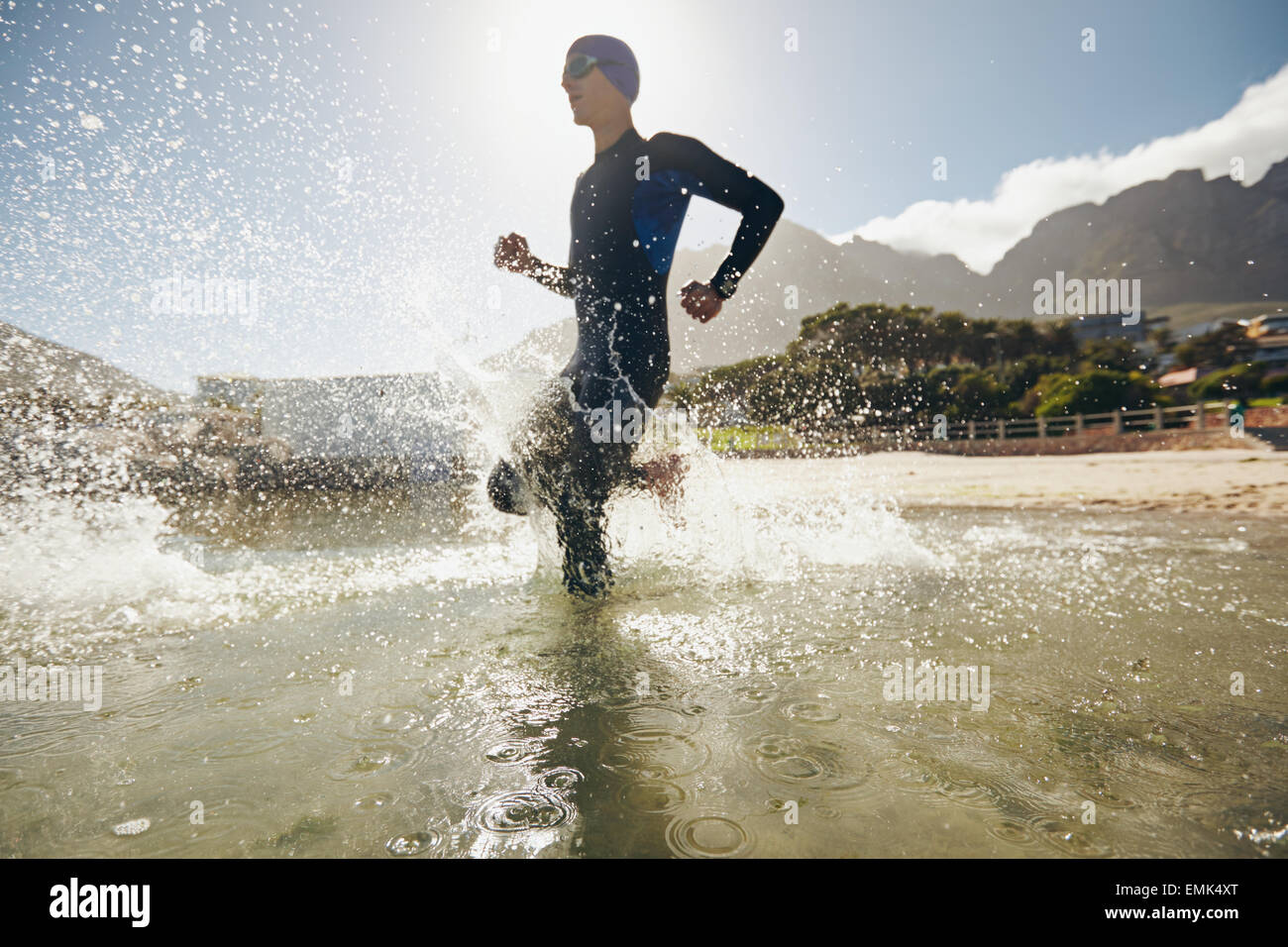 Triatleta maschio in esecuzione in acqua. La formazione per il triathlon concorrenza nel lago. Foto Stock
