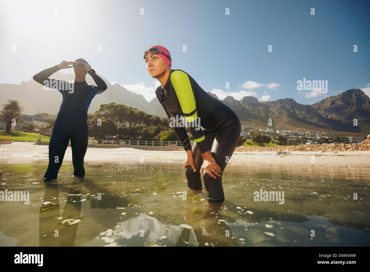 Sport di determinate persone in piedi in acqua ottenendo pronto per la concorrenza. Triatleti in mute la preparazione per il triathlon. Foto Stock