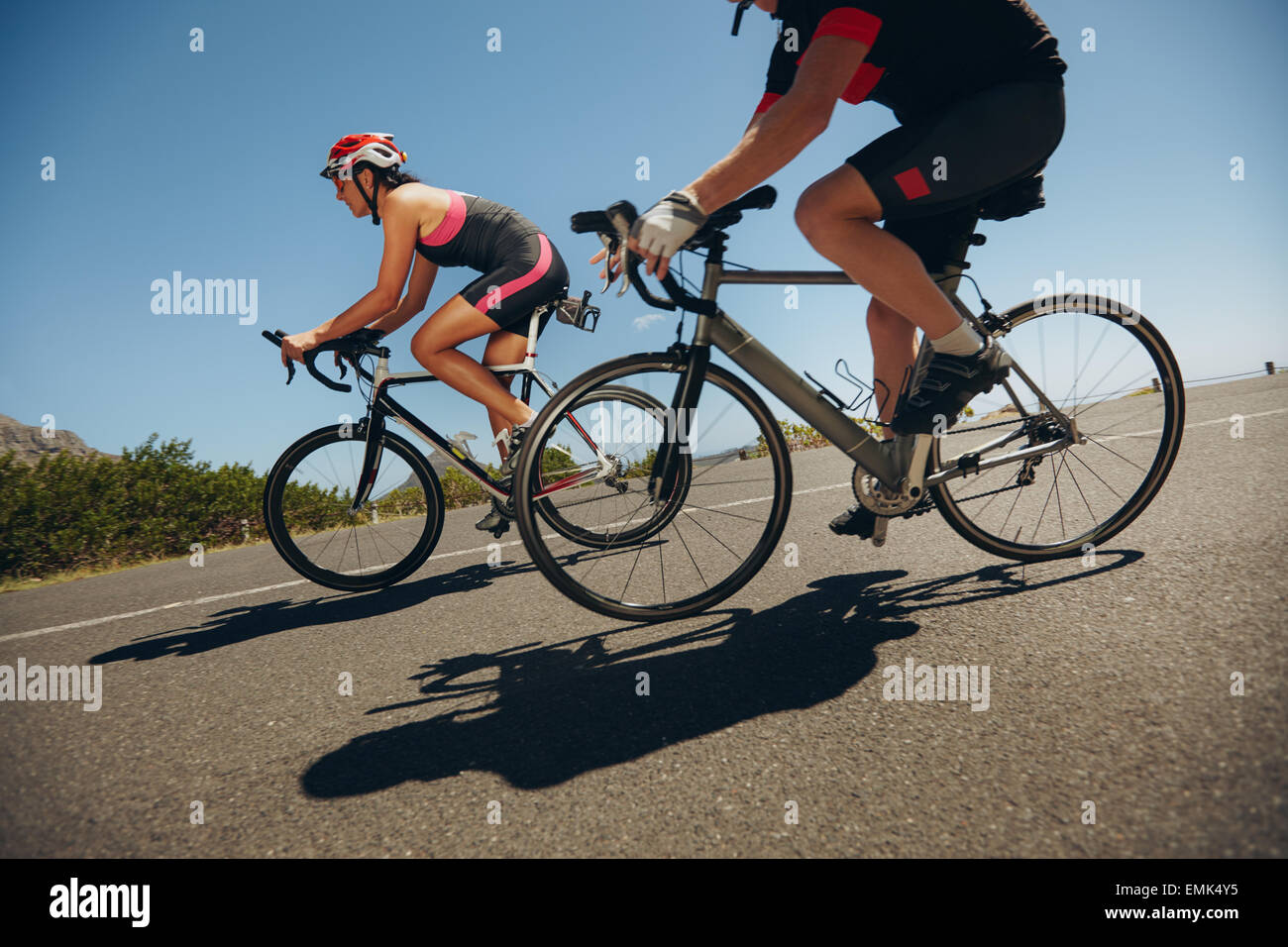 Azione girato di un racing ciclisti. Ciclista equitazione biciclette in discesa sulla strada di campagna. La pratica per la concorrenza. Foto Stock