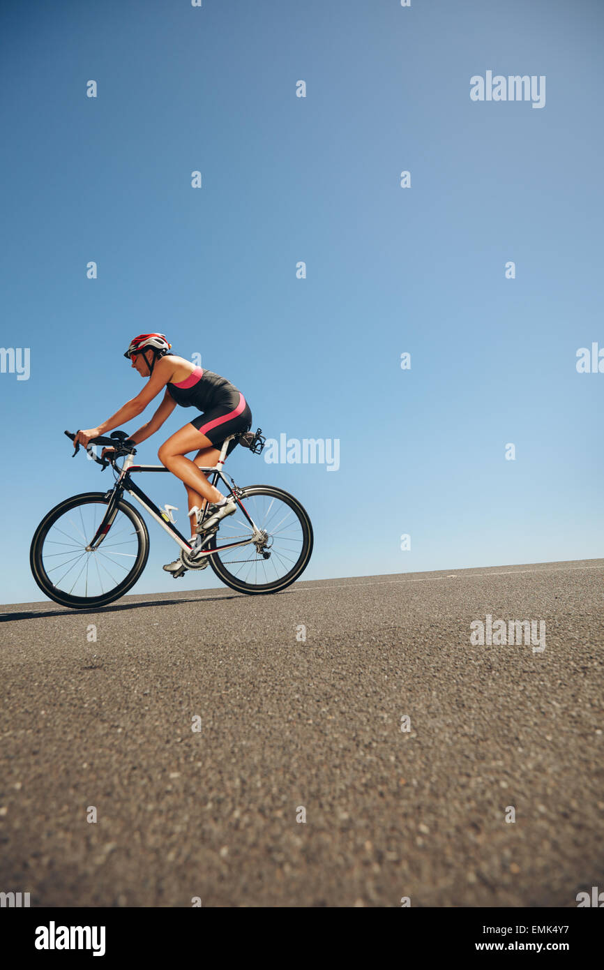 Immagine del ciclista femmina Bicicletta Equitazione giù per la collina. Atleta della formazione per la bicicletta in caso di triathlon. Foto Stock