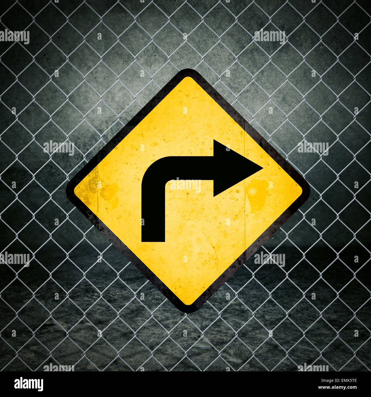 Giusta direzione Grunge simbolo giallo di avvertimento sulla catena collegamento recinto di magazzini industriali Foto Stock