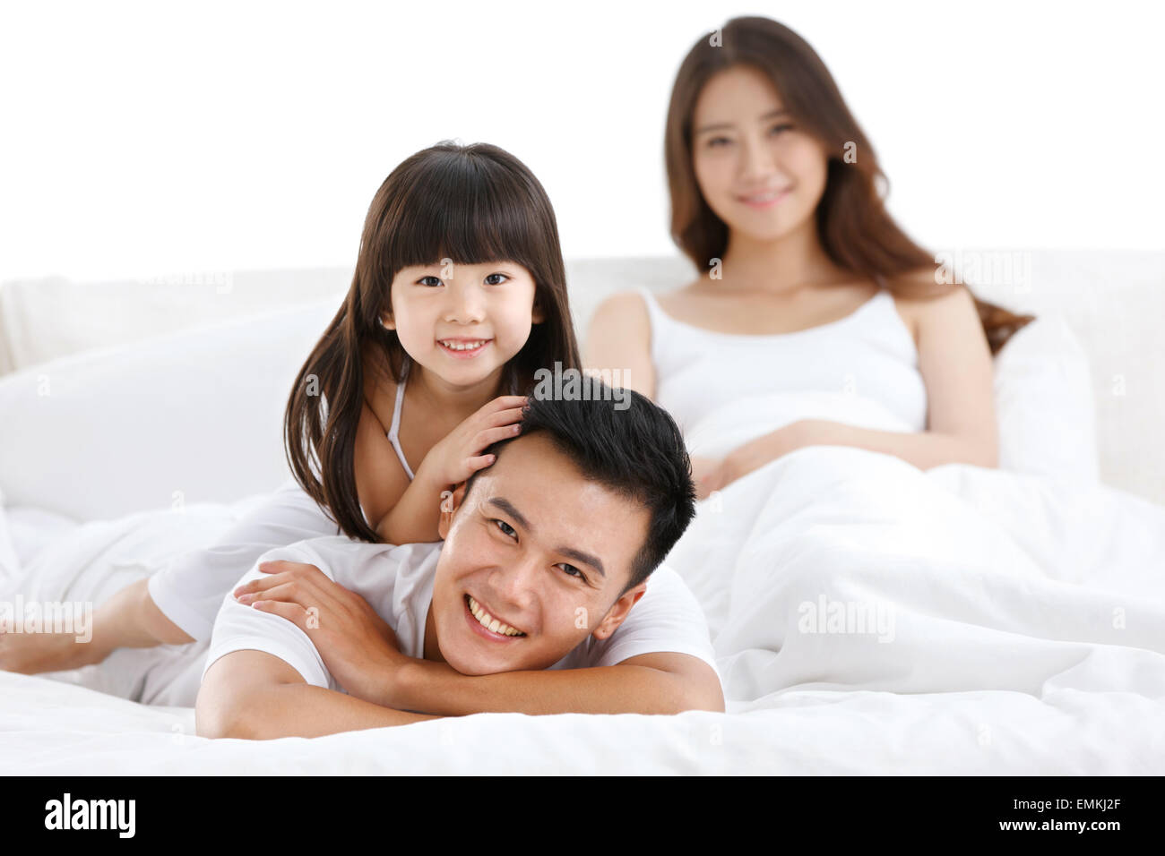 Una famiglia di tre persone nel letto della camera da letto per giocare Foto Stock