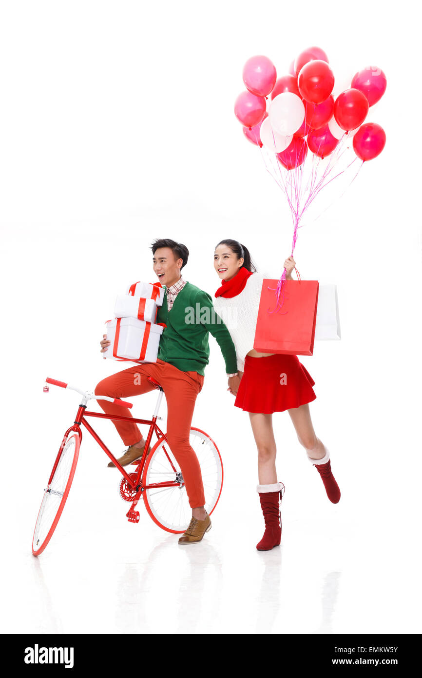 Romantico giovani amanti rode una bicicletta con un palloncino shopping Foto Stock