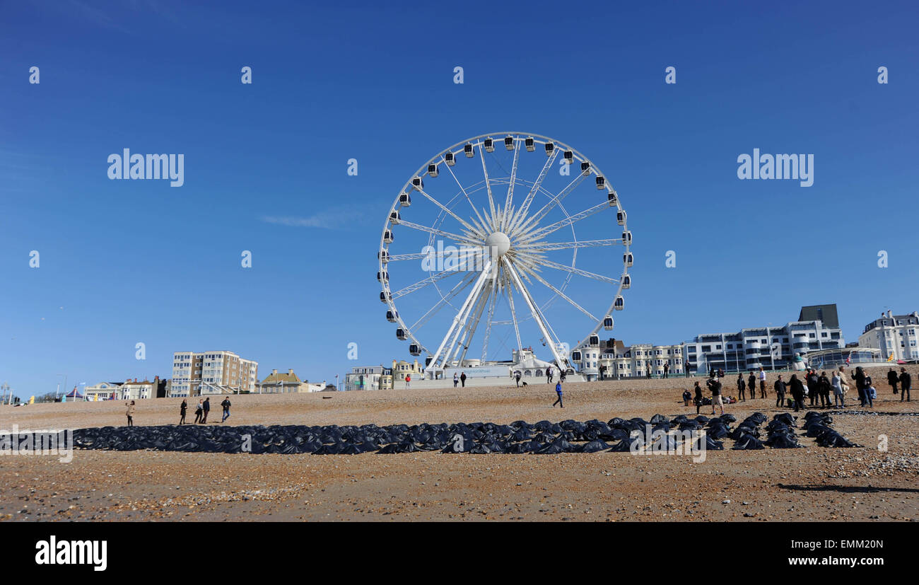 Brighton, Regno Unito. Il 22 aprile, 2015. I membri di Amnesty giacciono nel body bags sulla spiaggia di Brighton questa mattina per evidenziare il crescente problema dei migranti nel Mediterraneo Foto Stock