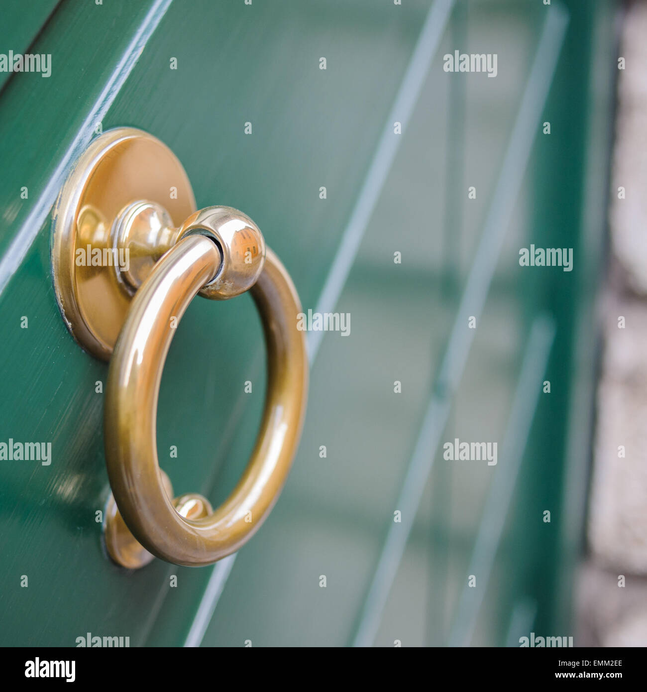 Respingente anello di ottone su una porta di legno di colore verde Foto Stock