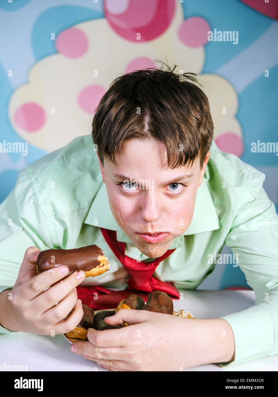 Funny ragazzo adolescente mangiare dolci, affamati e candy man Foto Stock