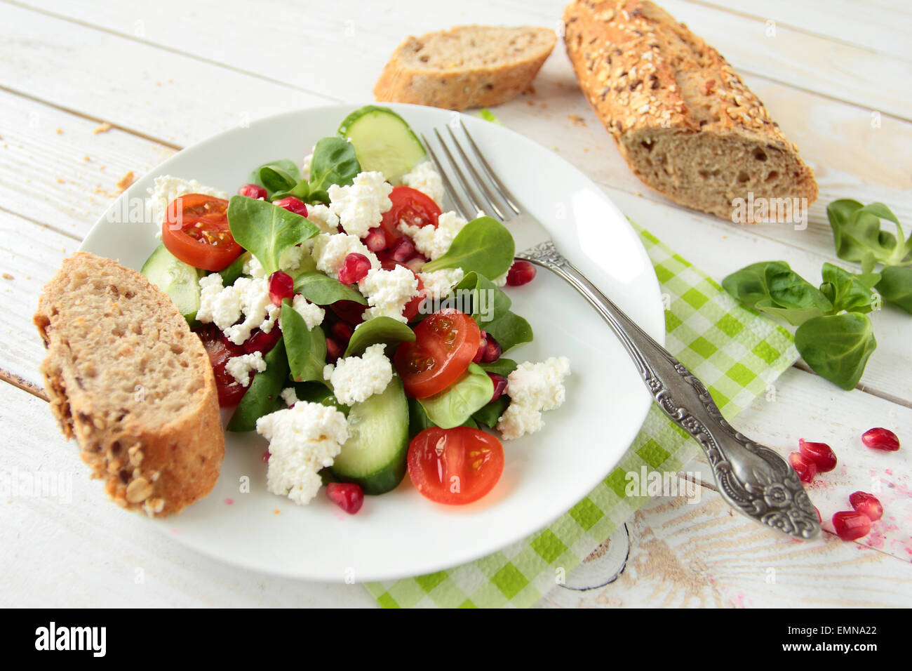 Una sana insalata di lattuga fresca, formaggio bianco e frutto di melograno Foto Stock