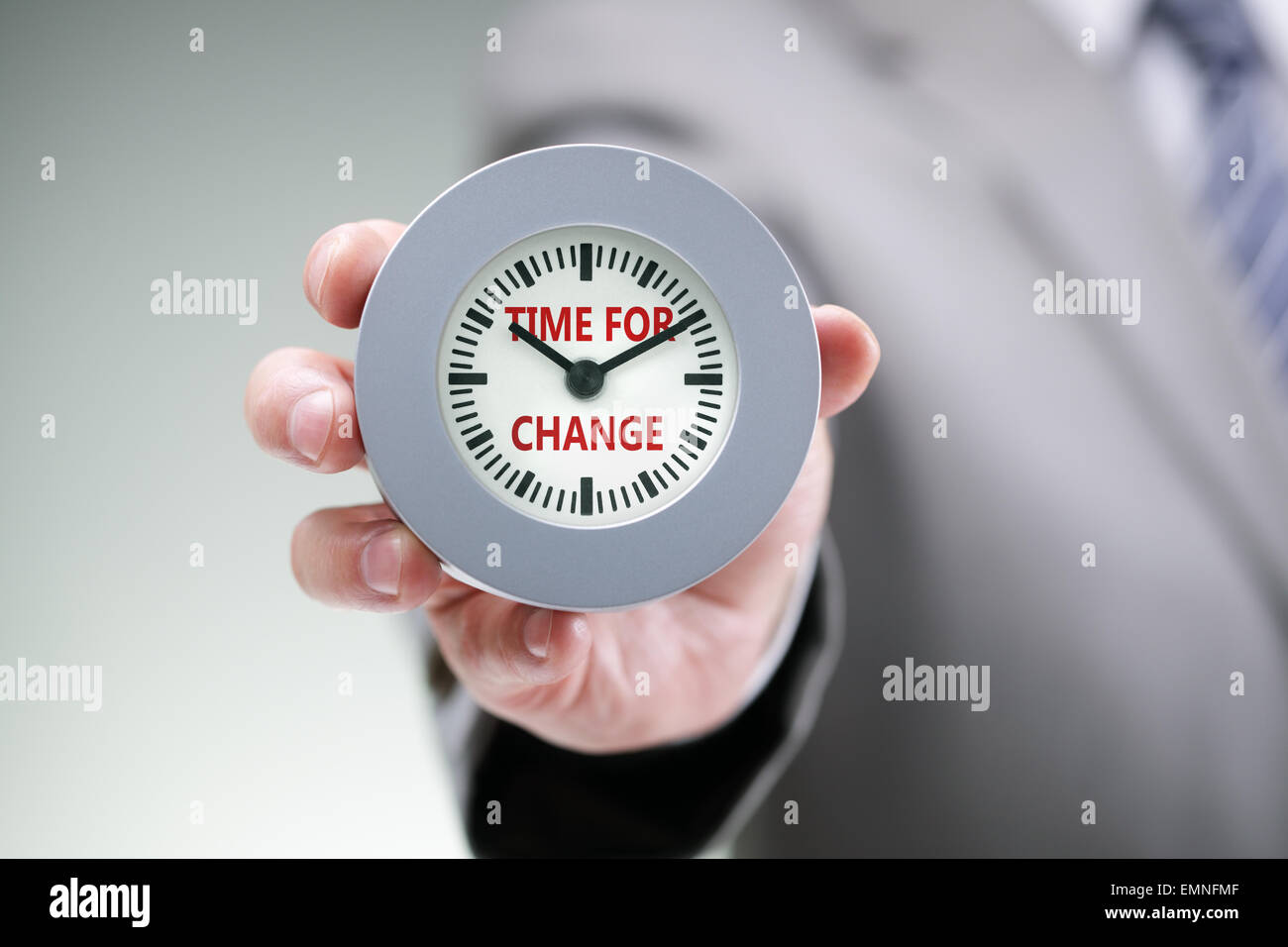 Imprenditore tenendo un orologio con il tempo per cambiare idea per la pianificazione, il miglioramento e il progresso Foto Stock