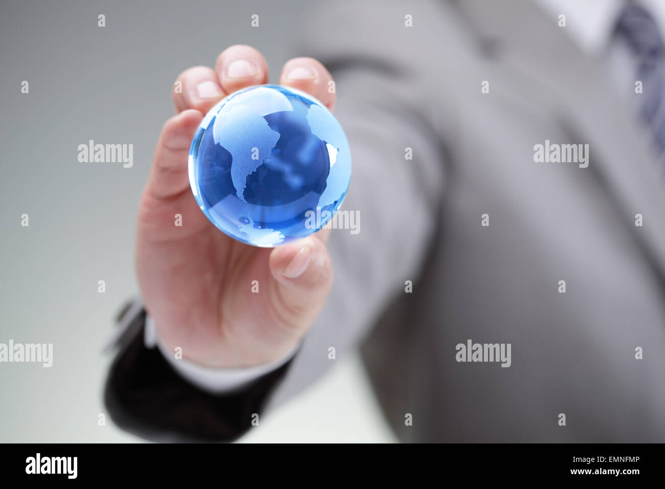 Business man tenendo un globo blu nel suo simbolo mano per le aziende globali, comunicazioni o la conservazione ambientale Foto Stock