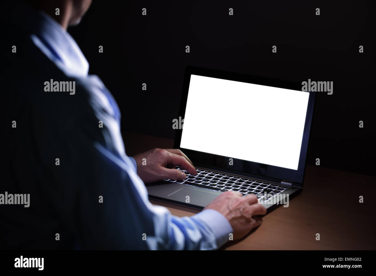 A tarda notte la dipendenza da internet o lavora fino a tardi Uomo con laptop ad una scrivania nel buio Foto Stock