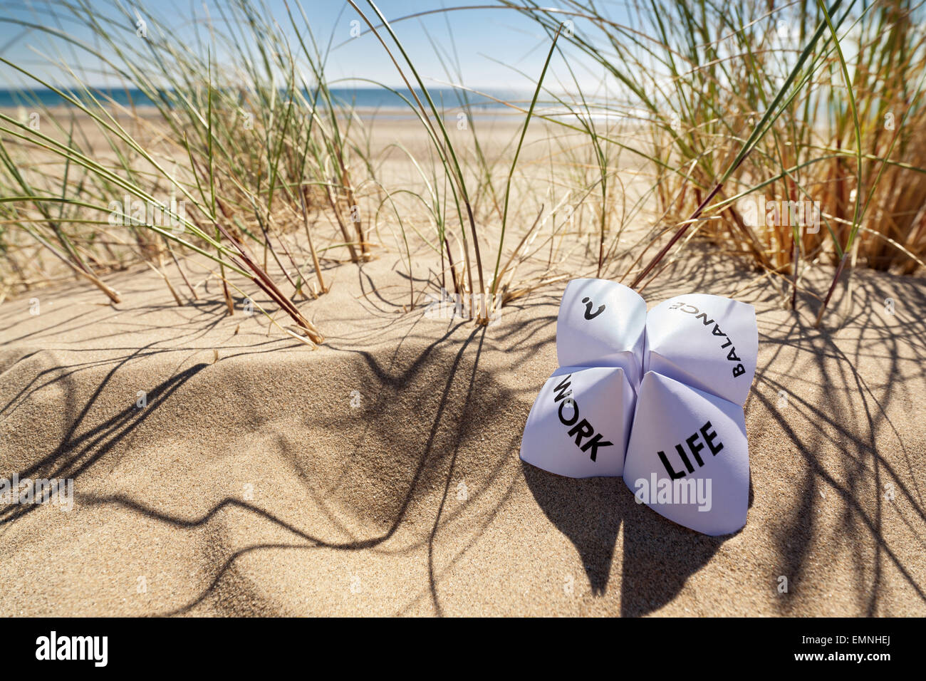 Origami fortune teller in vacanza in spiaggia per il concetto di equilibrio tra lavoro e vita familiare scelte Foto Stock