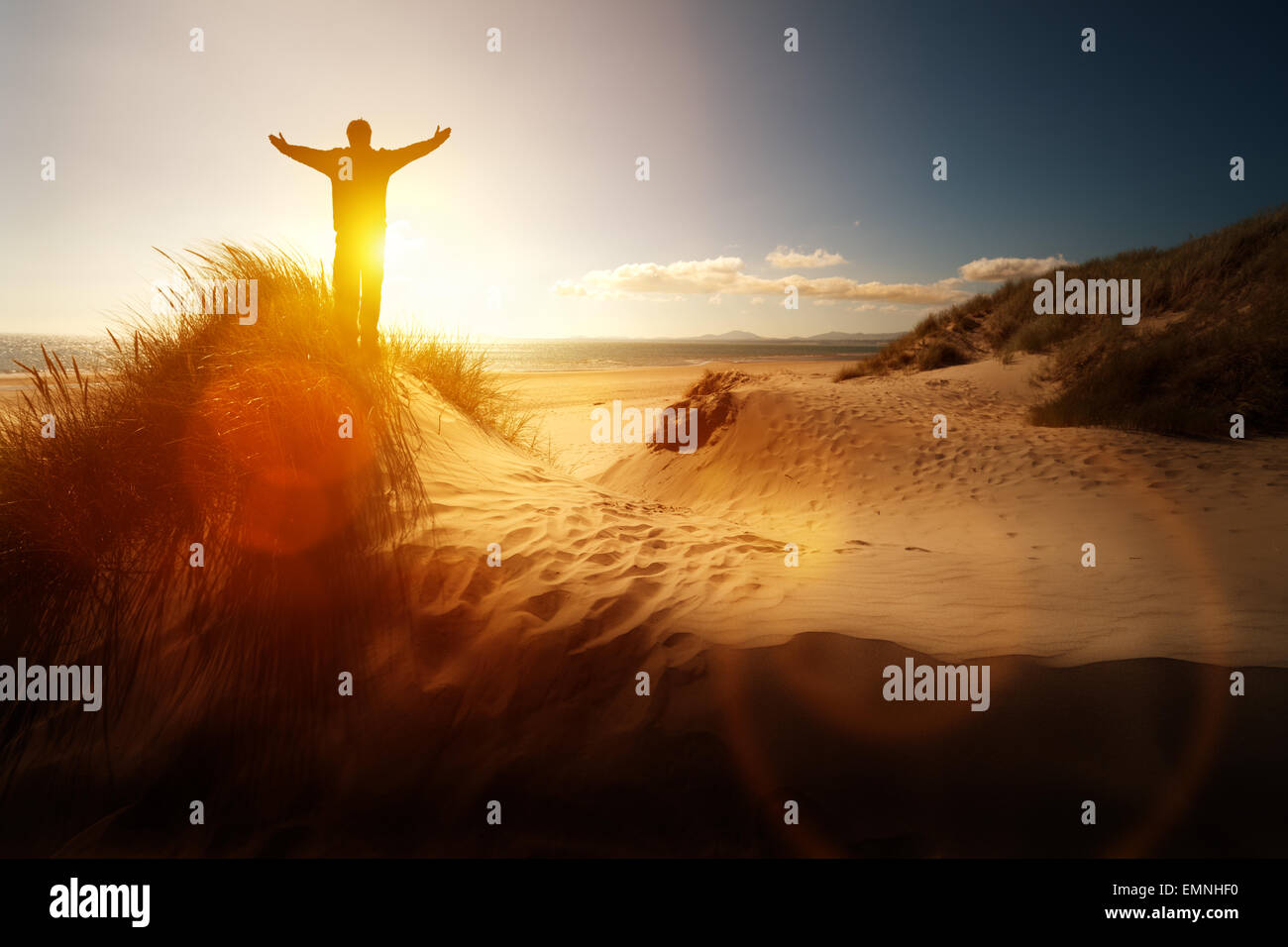 Silhouette di un uomo con le mani alzate il tramonto sulla spiaggia di un concetto per la religione, il culto e la preghiera e lode Foto Stock
