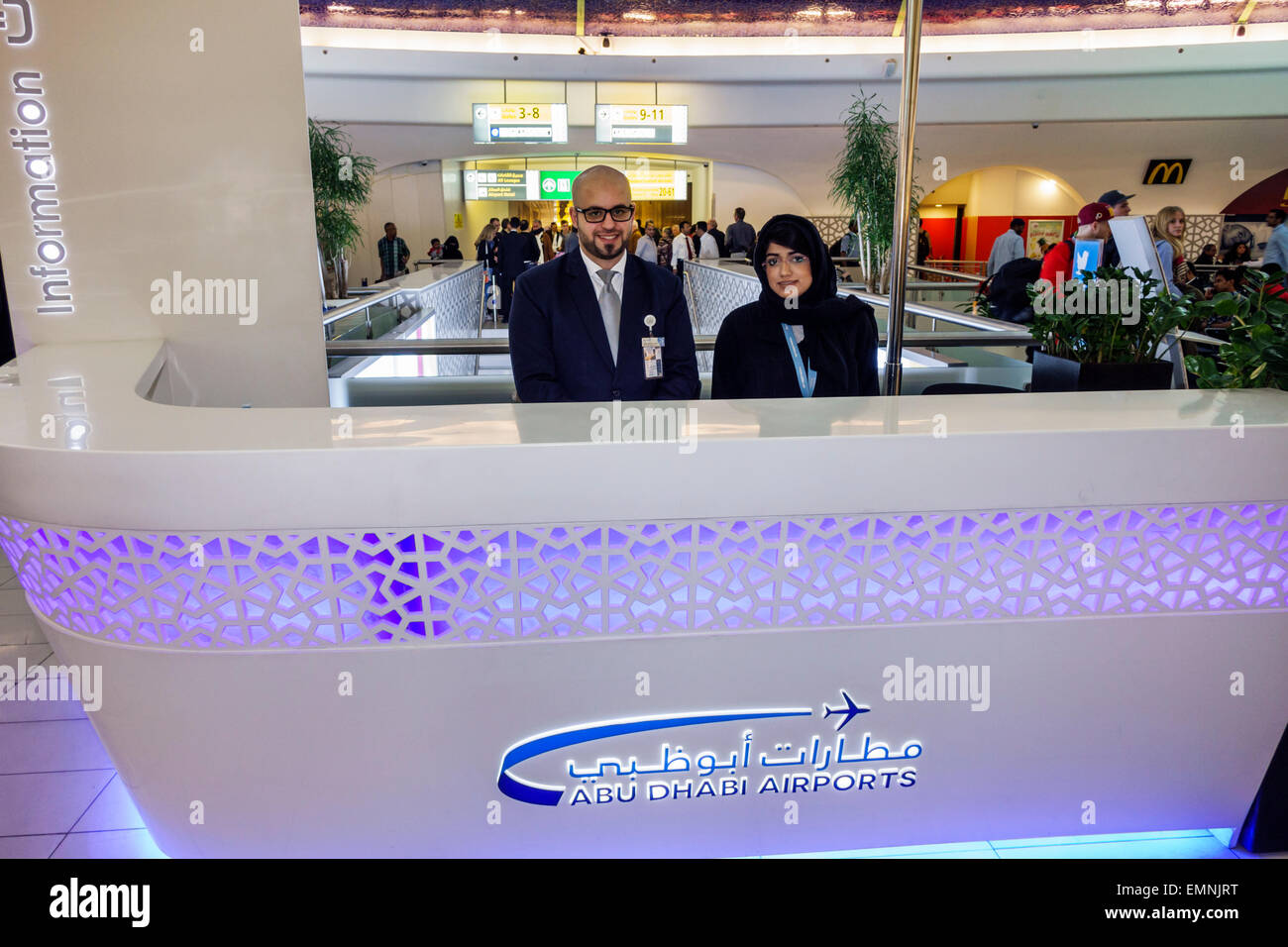 Abu Dhabi Emirati Arabi Uniti Emirati Arabi Uniti, Aeroporto Internazionale, AUH, terminal, cancello, interno, informazioni, scrivania, aiuto, inglese arabo, uomo uomo maschio, donna fem Foto Stock