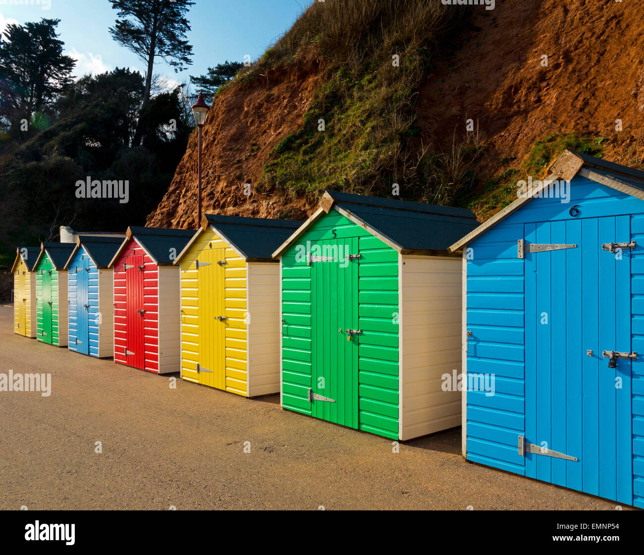 Vivacemente colorato in legno dipinto spiaggia tradizionali capanne sul lungomare a Seaton una località balneare nel South Devon England Regno Unito Foto Stock
