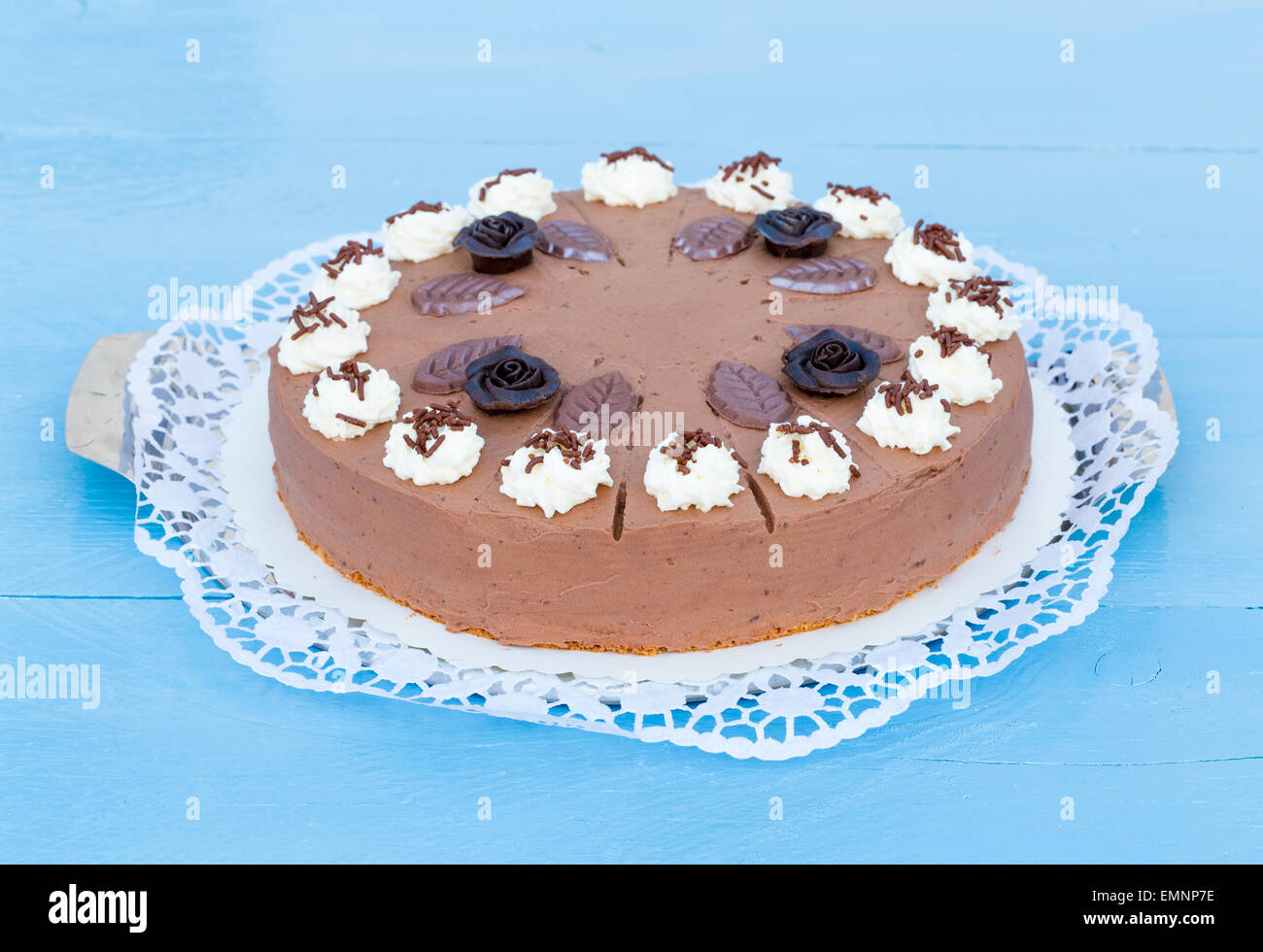 Crema di cioccolato torta su legno blu con torta di pizzo. Foto Stock