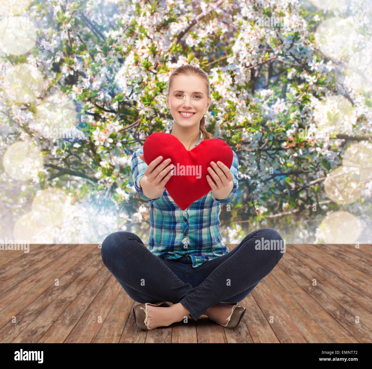 Giovane donna in abiti casual seduto sul pavimento Foto Stock