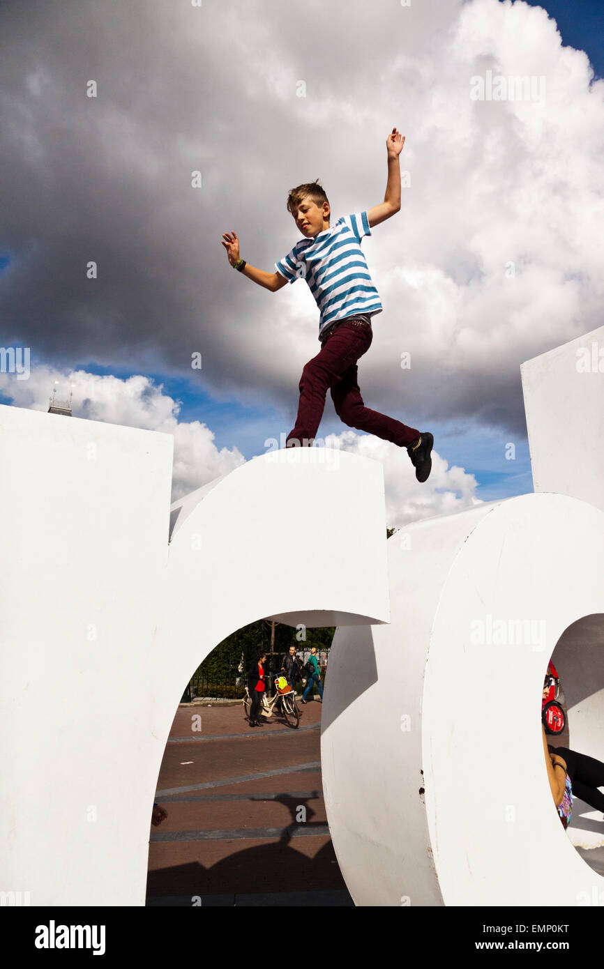 Ragazzo di saltare sul mio logo di amsterdam in Amsterdam Foto Stock