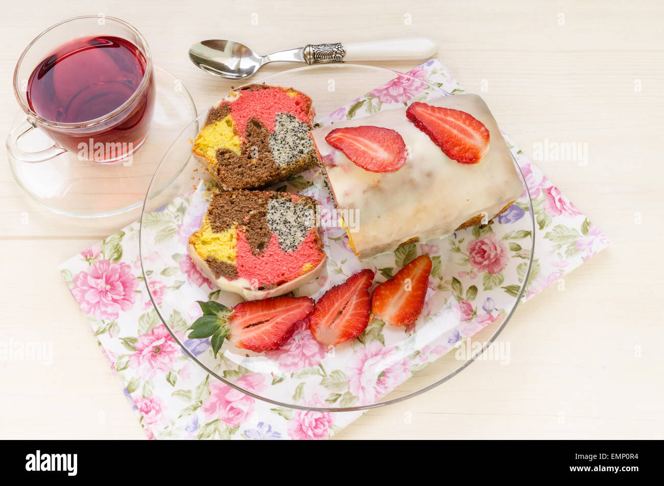 Fragola semi di papavero torta di cioccolato bianco smalto sulla lastra di vetro per la Festa della mamma. Prossima tazza di tè e fette di paglia fresca Foto Stock