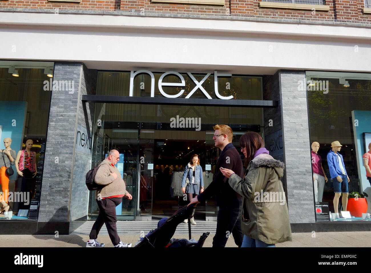 Il prossimo negozio di moda con gente camminare passato Foto Stock