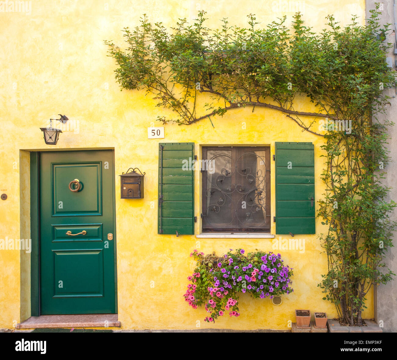 Via Mura Marini casa con la porta verde e corrispondenza di serrande nella città medievale di Santarcangelo di Romagna, Italia Foto Stock