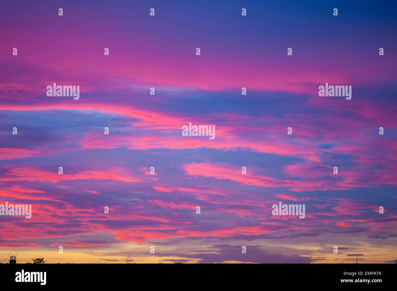 Nuvole illuminate dal sole di setting che mostra la parte inferiore rossa. Foto Stock