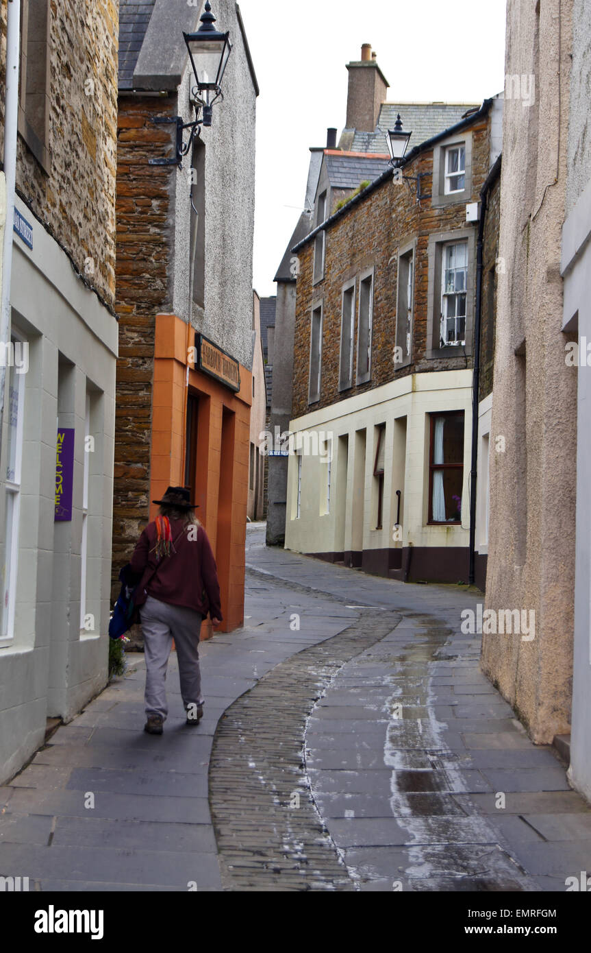 Una donna sola a piedi fino a Victoria Street, Stromness, Orkney Islands, Scozia Foto Stock