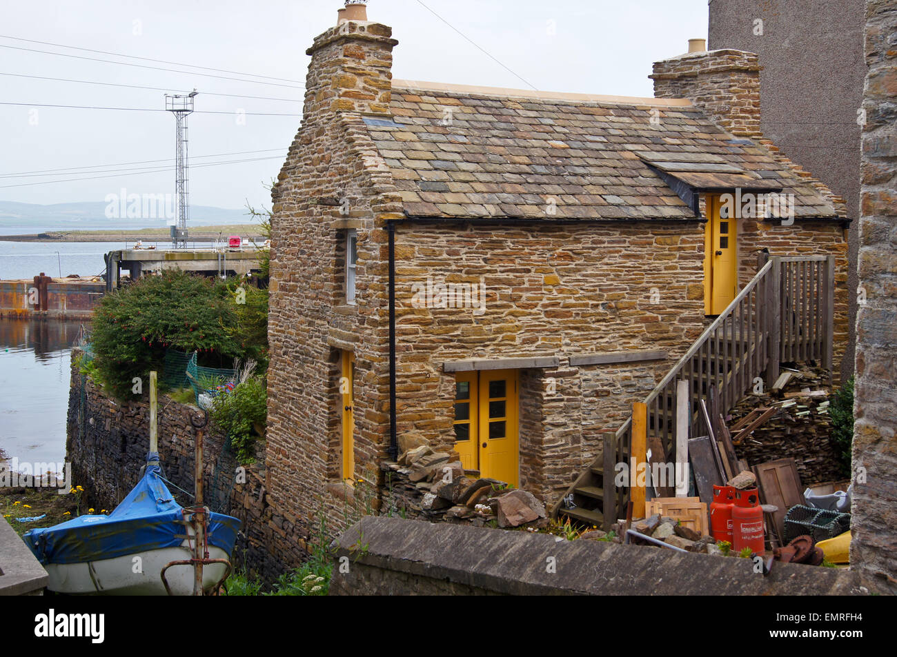 Fisherman's cottage di ardesia sul porto con il suo scalo, Stromness, Orkney Islands, Scozia Foto Stock