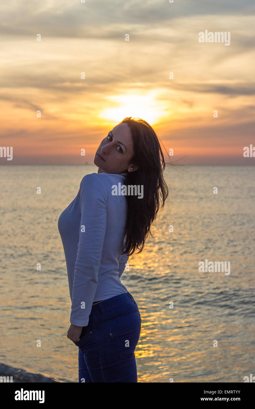 Donna tramonto brunette girl mare spiaggia relax resto Foto Stock