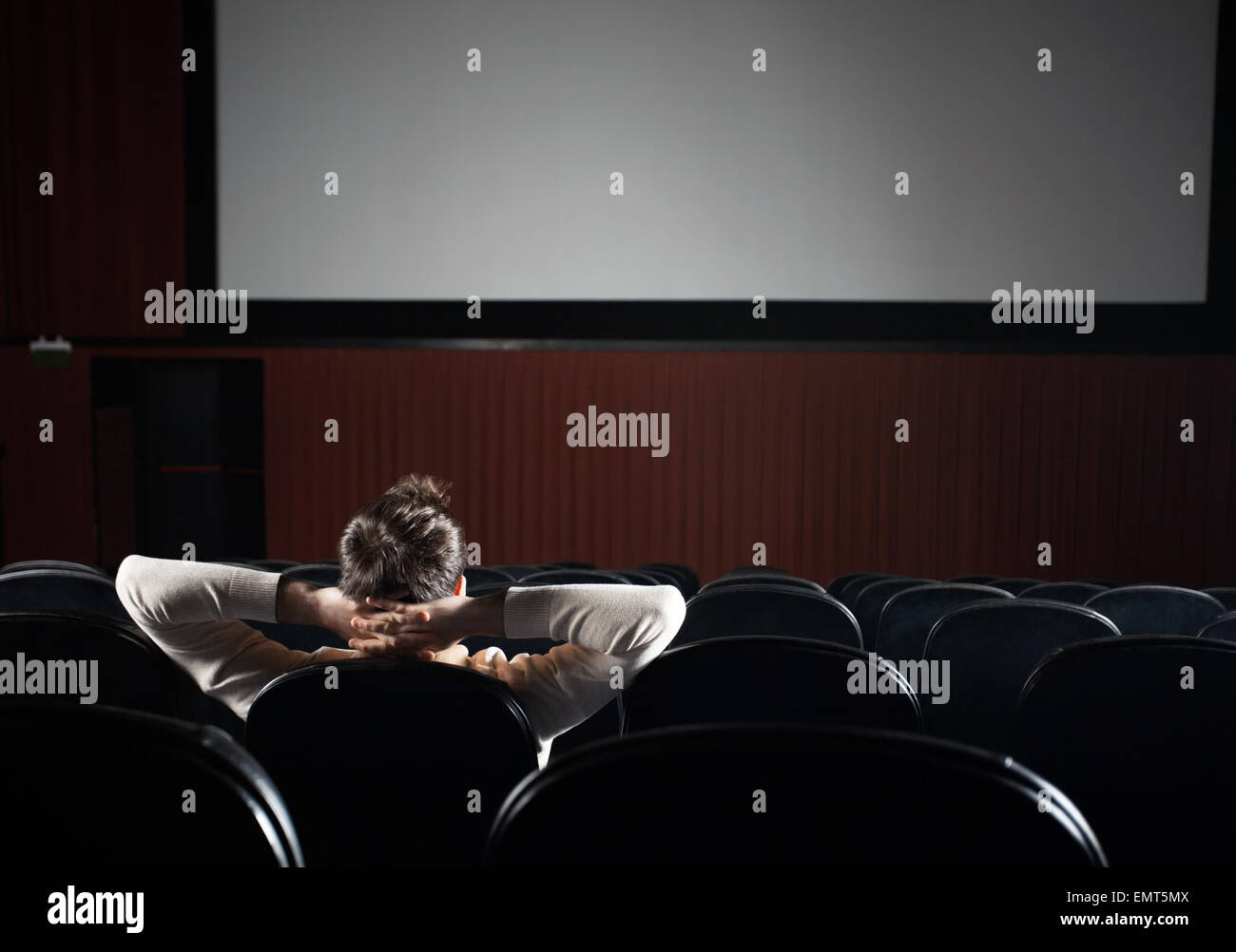 Uomo rilassati guardando film in teatro Foto Stock