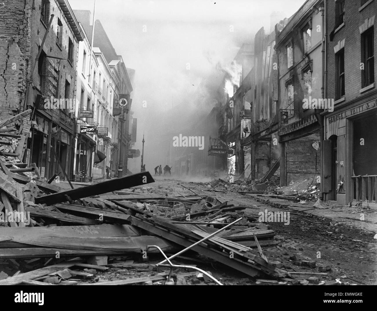 I vigili del fuoco si vede qui combattere il fuoco al Queens Hotel a Hertford Street, Coventry, prima di decidere di soffiare l'edificio fino a impedire la propagazione di un incendio all'ufficio postale in seguito alla precedente notti air raid. Tra la devastazione gettare i corpi o Foto Stock