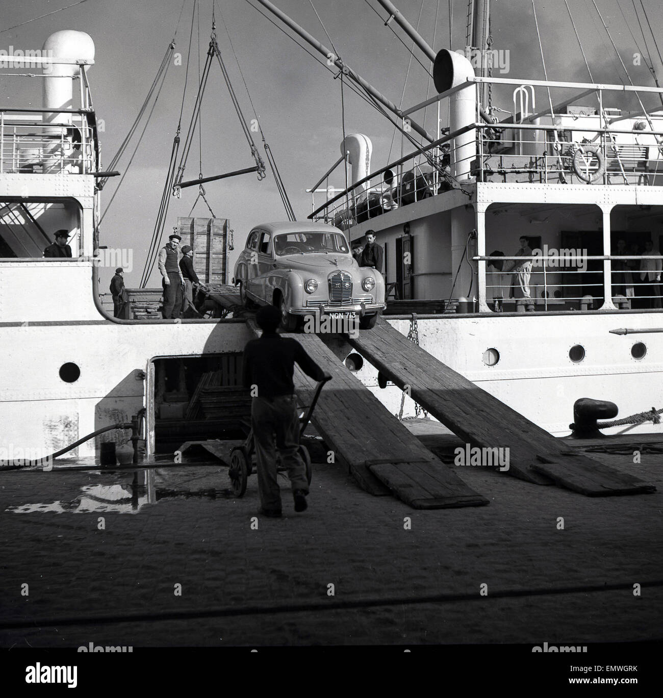 Anni Cinquanta storiche, Austin A40 auto viene scaricato dal ponte di una nave al porto di Palma, isola di Maiorca, Spagna. Foto Stock